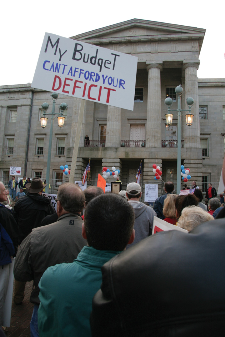 Photo of a Tea Party rally. One sign reads, "My budget can't afford your deficit."