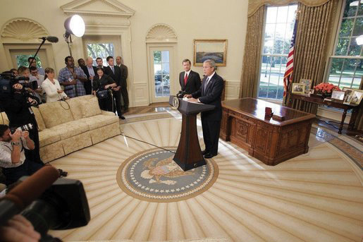 Photo of President George W. Bush in the Oval Room with John Roberts and a small crowd of journalists.