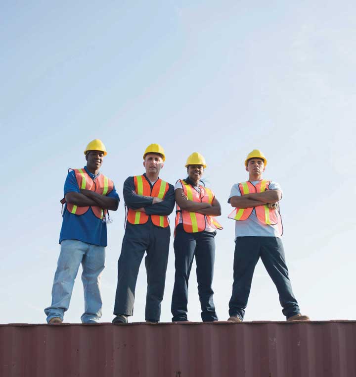 Four men standing on a large I beam